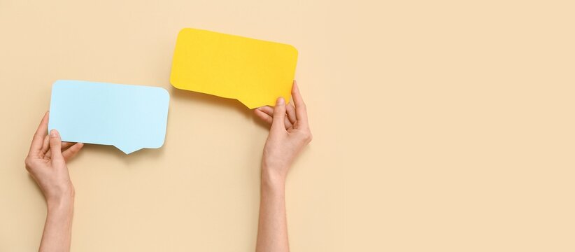 Hands and blank speech bubbles on beige background with space for text