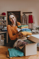 Female volunteer sorting old clothes for charity or upcycle