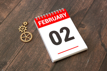 Calendar with date February 2nd on light blue background, closeup.