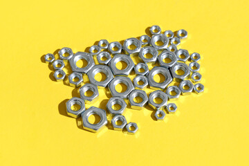 Many chrome nuts on yellow background