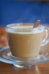 A Steaming Cup of Coffee Accompanied by a Spoon on a Wooden Table