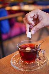 A Sugar Cube Delicately Being Added to a Warm Cup of Coffee, Enhancing the Experience