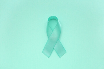 Turquoise ribbon on color background. Cervical Health Awareness Month