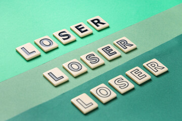 Words LOSER on green background, closeup