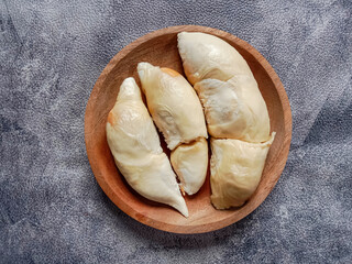 Durian pulp in wooden plate on white background. Durian flesh in wooden plate. Peeled durian fruit.