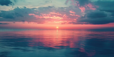 Obraz premium A serene beach scene with a vibrant sunset, reflecting on the calm ocean waters.