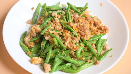 fried green bean with pork on white plate, thai and chinese food