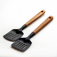 Naklejka premium Two sleek black spatulas with elegant wooden handles, perfect for cooking.