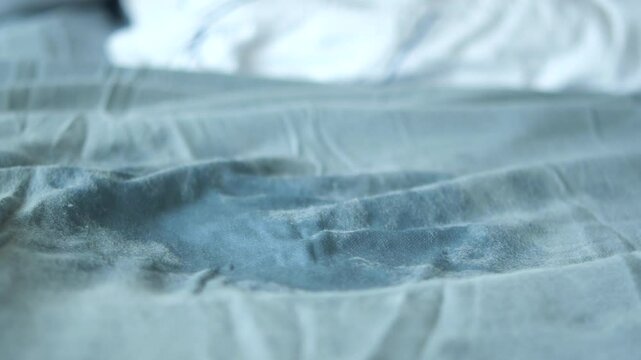 A visible stain on a light blue bedsheet
