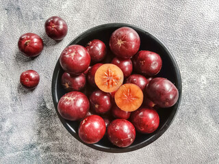 Flacourtia fruit in a bowl. Rukam, ramontchi, governor's plum, Indian plum, and Indian prune. Bowl of fruits.