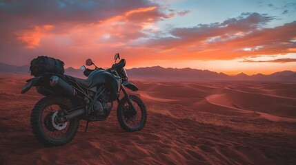 A remote desert with red sand dunes and a vibrant orange and pink sunset sky in the background