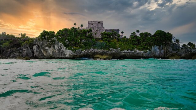Golden sunset over El Castillo and the UNESCO world heritage monuments and ruins of the 13th century Tulum Mayan Ruins, overlooking the azure waters of the Caribbean Sea in Tulum,Mexico 