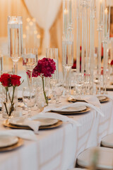 Luxurious Wedding Table Setting with Elegant Floral Arrangements, Gold Accents, and Crystal Candle Holders in a Sophisticated Reception Venue