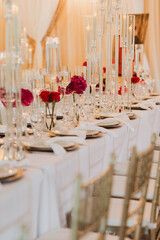 Elegant Wedding Reception Table Setting with Vibrant Floral Centerpieces, Crystal Candle Holders, and Gold Details in a Luxurious Banquet Hall