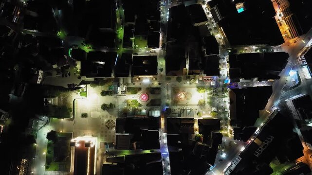 Aerial: Top down drone shot of central square in Pyrgos, Elis province at night