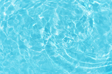Blue water with ripples on the surface. Defocus blurred transparent blue colored clear calm water surface texture with splashes and bubbles. Water waves with shining pattern texture background.