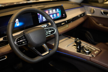Closeup of a modern car steering wheel with control buttons for technology and convenience