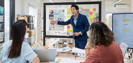 Group of young Asian professionals collaborating presentation project meeting in a modern office. Brainstorming innovative ideas for a new business venture.
