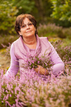 A portrait of an older Swedish woman with flowers outside in the nature
