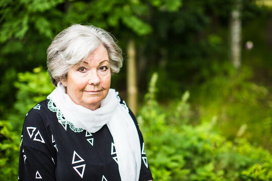 A portrait of a senior woman outside in nature