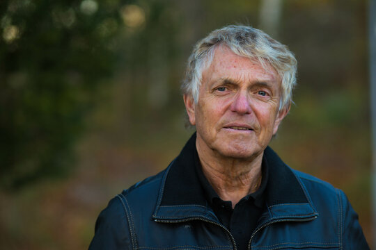 A portrait of an older nordic man outside in the Swedish nature