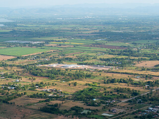 Panoramic view of a village by the river with hills, fields