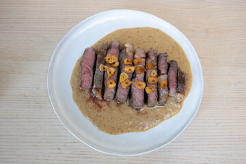 A plate of steak with peppercorn sauce.