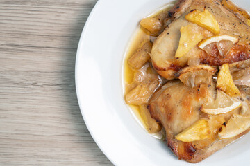 Baked chicken thighs with pineapple on wood table, Top view