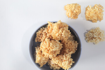 Rengginang or arangginang or rangginang in a small bowl on a white background. Traditional Indonesian snack made from sticky rice and then fried.
