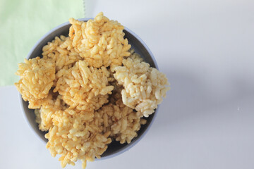 Rengginang or arangginang or rangginang in a small bowl on a white background. Traditional Indonesian snack made from sticky rice and then fried.