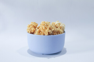 Rengginang or arangginang or rangginang in a small bowl on a white background. Traditional Indonesian snack made from sticky rice and then fried.