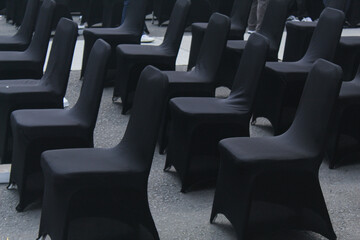 Fototapeta premium Black chairs were lined up very neatly outside in preparation for the event