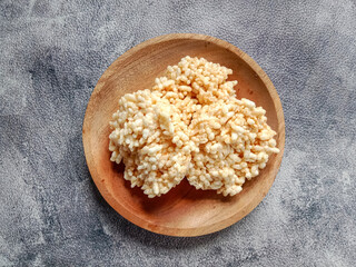 Rengginang or rice cracker, traditional snacks made from glutinous rice, savory and crunchy. Served on wooden plate. Top view. Indonesian food.