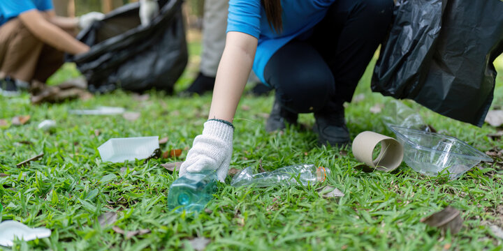 Family volunteers collect garbage in nature environmental clean-up event community effort park positive impact