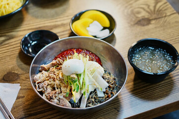 식탁 위에 차가운 비빔냉면이 놓여 있는 모습