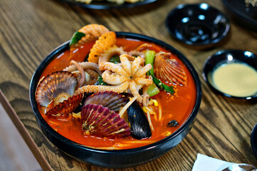 식탁 위에 얼큰한 해물짬뽕과 탕수육이 놓여 있는 모습