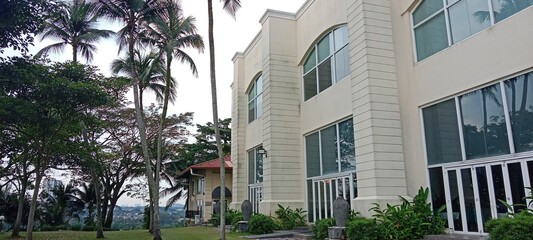 Elegant building surrounded by lush greenery and palm trees.