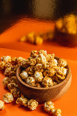 Sweet Caramelized Popcorn in a Wooden Bowl on an Orange Gold Background