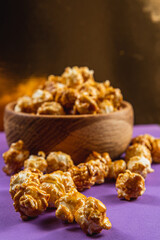 Sweet Caramelized Popcorn in a Wooden Bowl on a Purple Bright Background