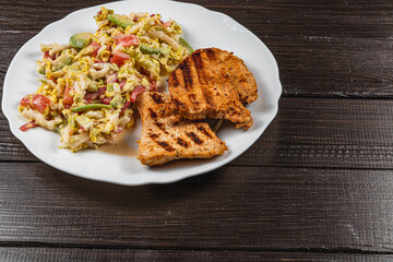 Delicious Grilled turkey Served with a salad on a Rustic Wooden Dining Table