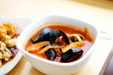 식탁 위에 홍합 짬뽕이 놓여 있는 모습