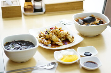 식탁 위에 짜장면 짬뽕 탕수육이 놓여 있는 모습