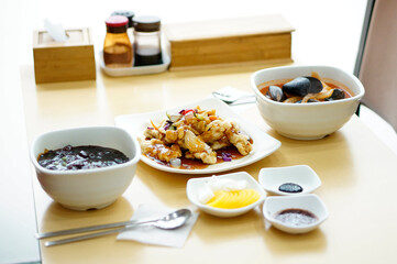 식탁 위에 짜장면 짬뽕 탕수육이 놓여 있는 모습