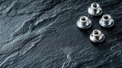 Steel tapping screws on textured black surface showcasing industrial hardware, perfect for design and engineering concepts with copy space.