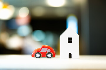 Car and house model in wood table, concepts of contract to buy, get insurance or loan real estate...
