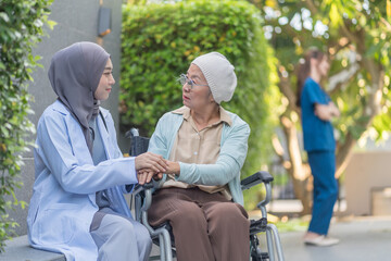 a young female health care worker in hijab take care senior cancer patient in wheelchair,talking,empowering,empathy,mental care