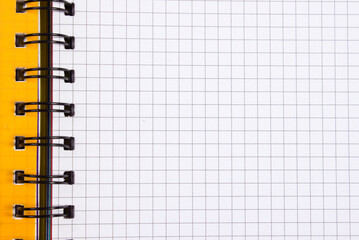 an open yellow notebook with checkered leaves and a place for text