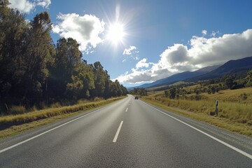 Fototapeta premium Sunny road trip through mountains and fields.