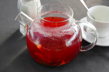 Hot berry tea (cranberries and lingonberries) brewed in a glass teapot