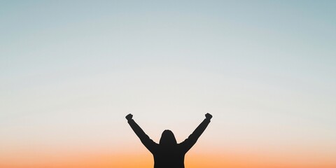 Women's day achievement concept. Silhouette of a person celebrating at sunset with raised arms.